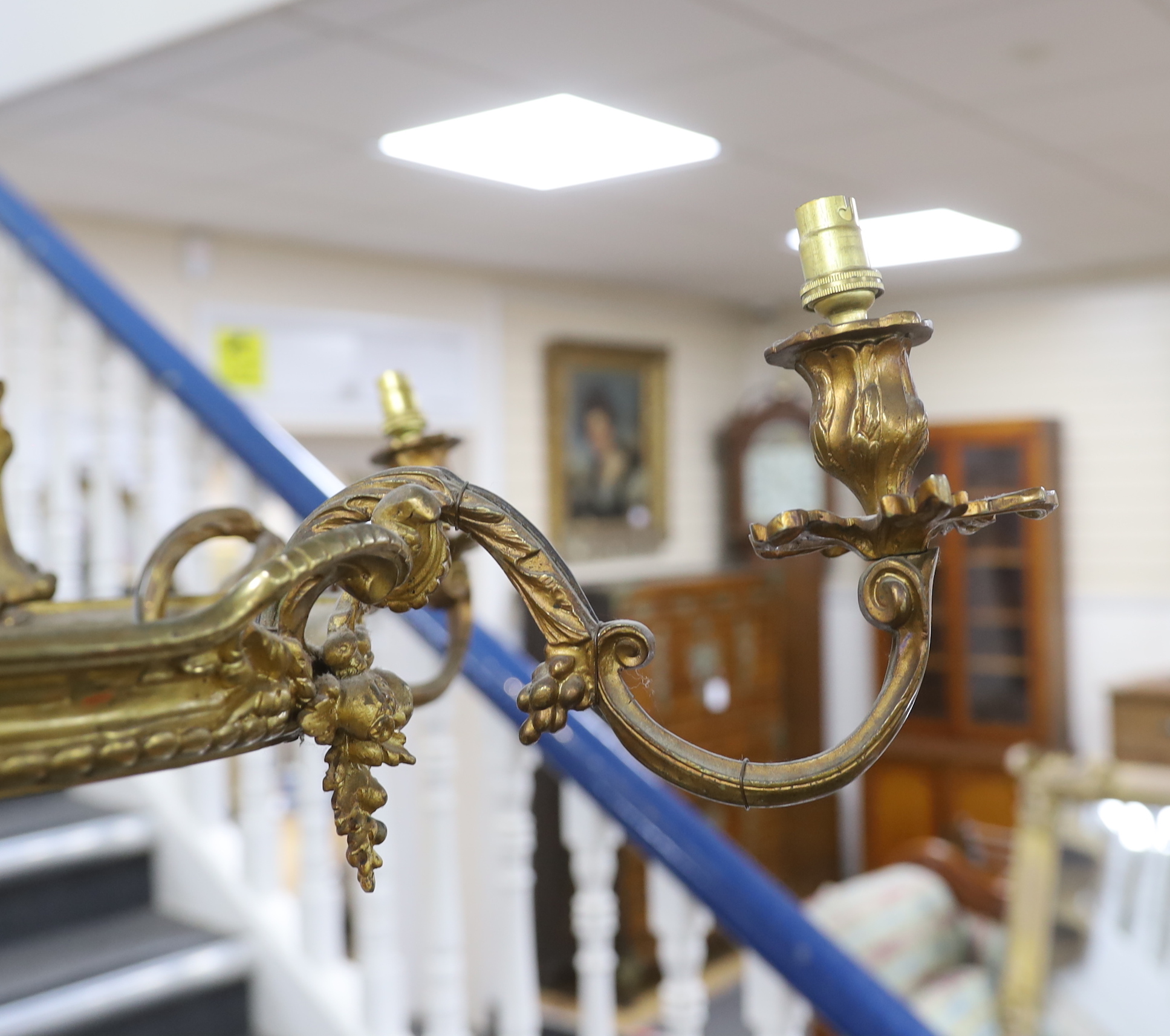 A gilt metal five branch chandelier, decorated with masks, 78cm high